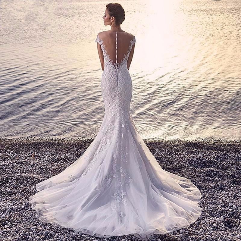 Robe de mariée sirène de princesse, blanche, traînante, transparente, dos nu, en dentelle