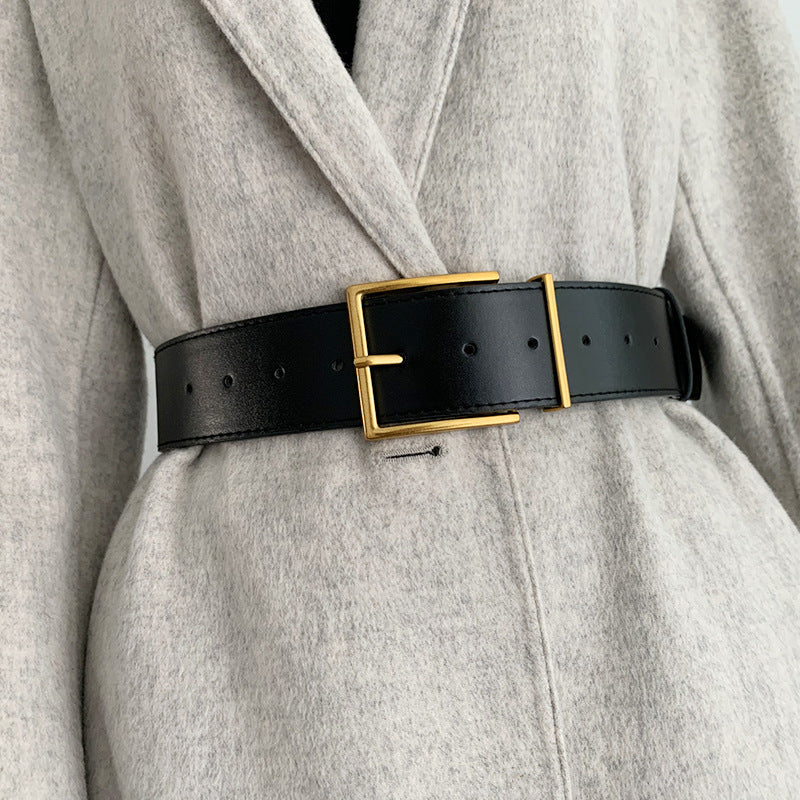 Un tailleur élégant rehaussé d'une large ceinture noire pour femme