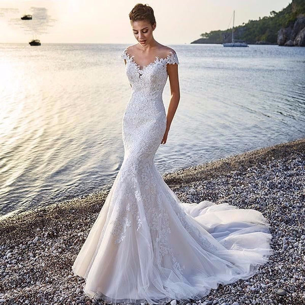 Robe de mariée sirène de princesse, blanche, traînante, transparente, dos nu, en dentelle